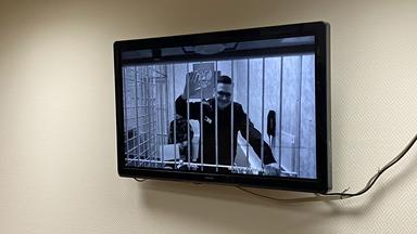 Ilja Jaschin winkt aus seinem Angeklagtenstand vor Gericht.