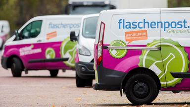 Lieferfahrzeuge von Flaschenpost fahren auf dem Gelände eines Logistikzentrums