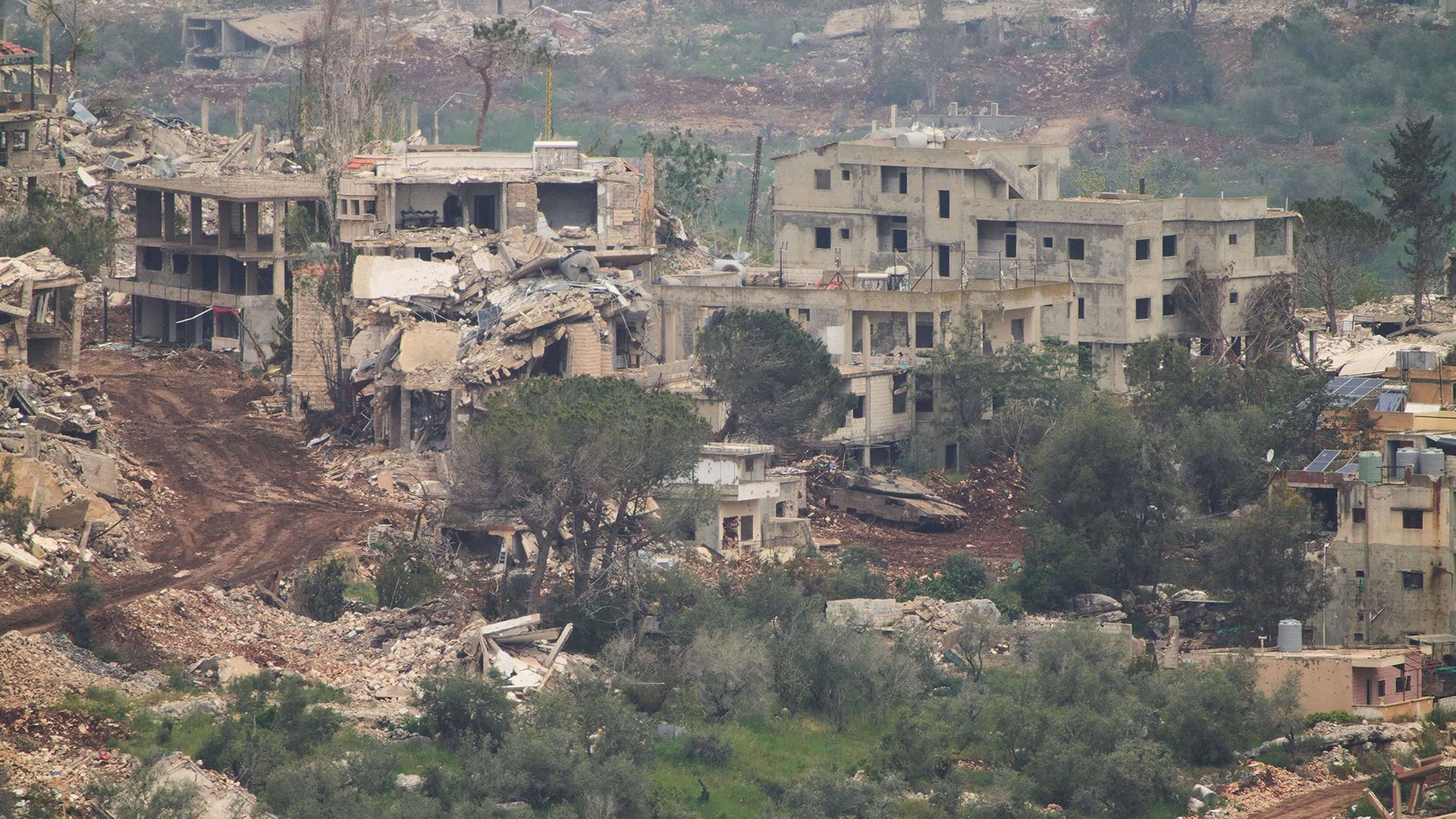 Ein Panzer fährt durch ein Dorf im Südlibanon. | Ariel Schalit/AP/dpa