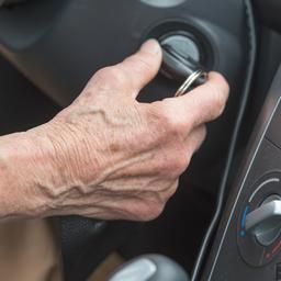 Eine Rentnerin startet ihr Auto.