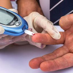 Ein Mann lässt sich von einer Diabetesberaterin eine Blutprobe für einen Blutzuckertest nehmen.