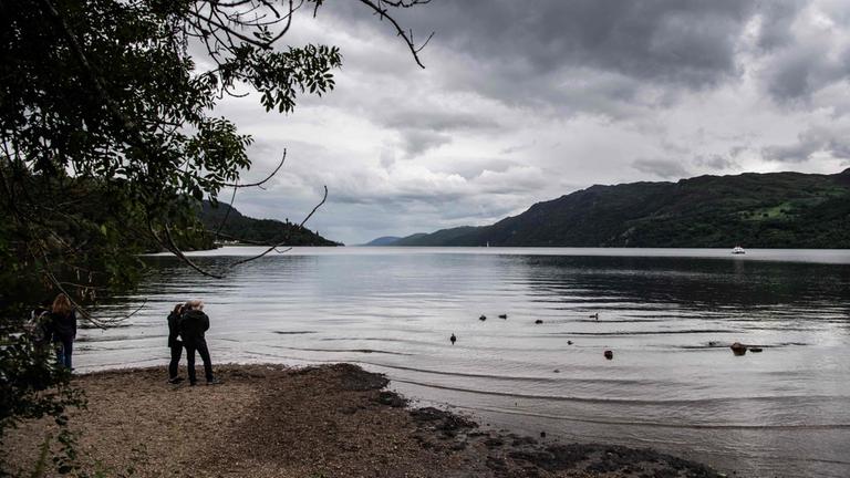 Zwei Personen stehen am Ufer des Loch Ness