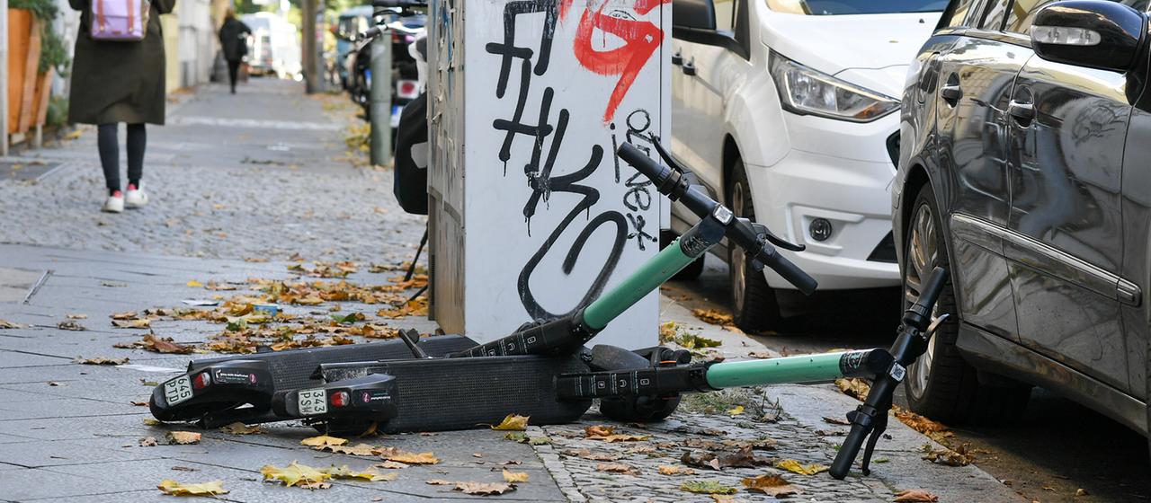 E-Scooter liegen auf einem Gehweg.