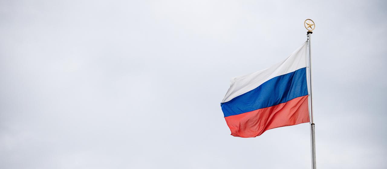 Die russische Flagge hängt an einem Fahnenmast. 