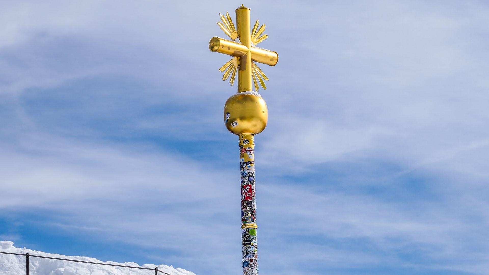 Hunderte Aufkleber auf dem vergoldeten Gipfelkreuz der Zugspitze | picture alliance / Sportpics | Marc Schueler