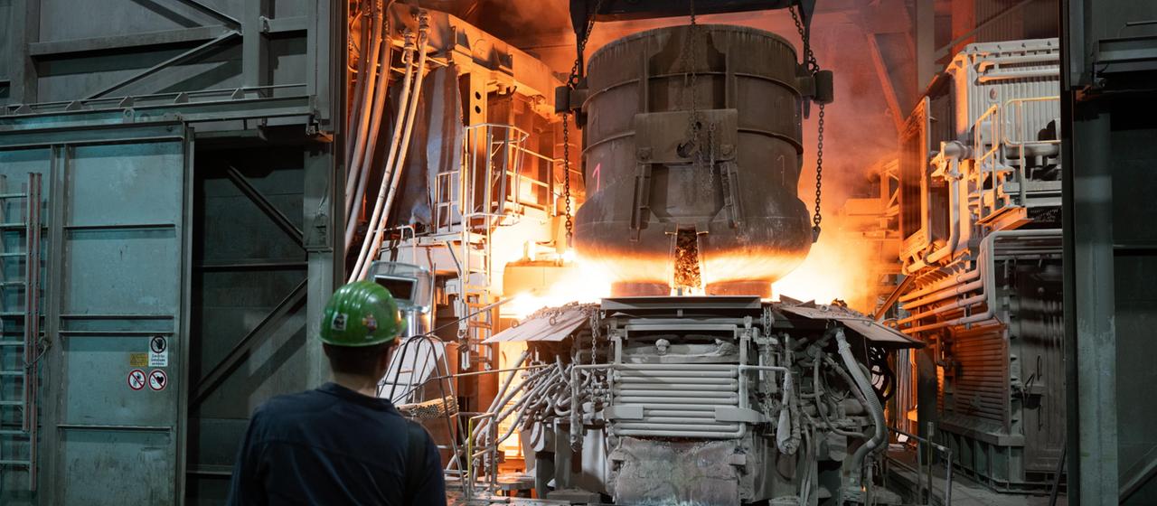 Ein Mitarbeiter steht in einer Werkhalle der BGH Edelstahl Freital GmbH an einem Lichtbogenofen.