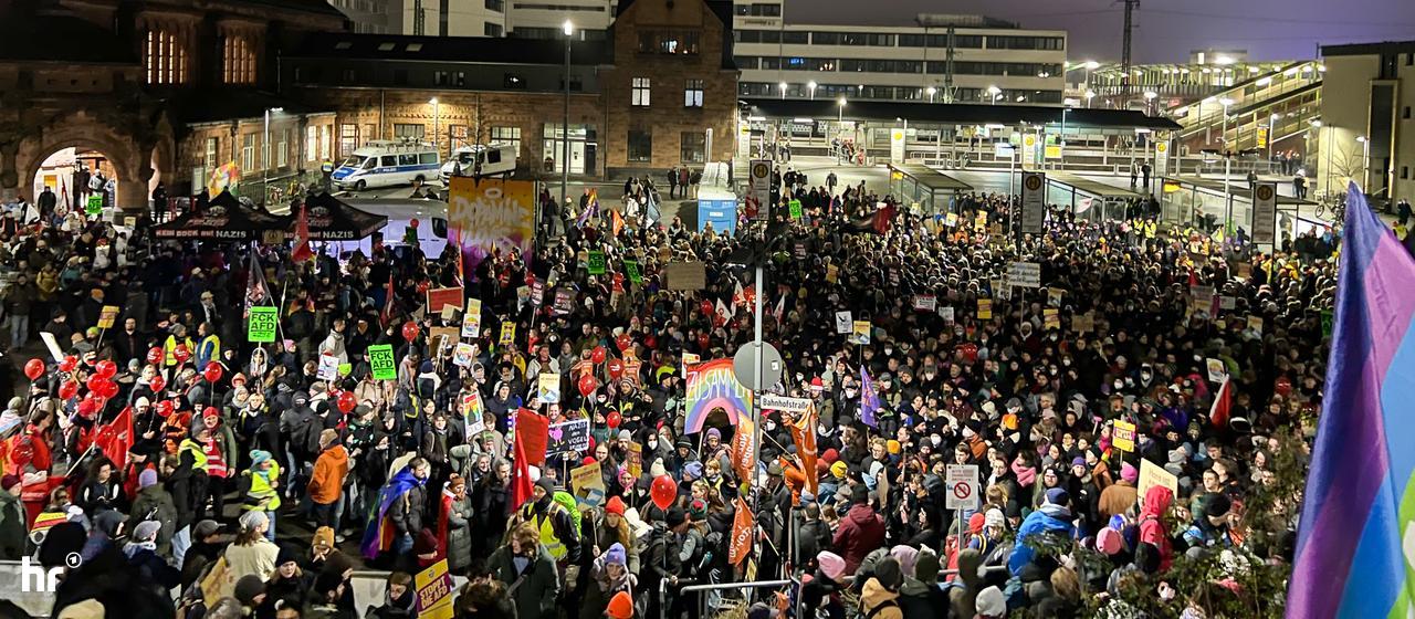 Vogelperspektive auf zahlreiche Menschen mit Luftballons und Schildern