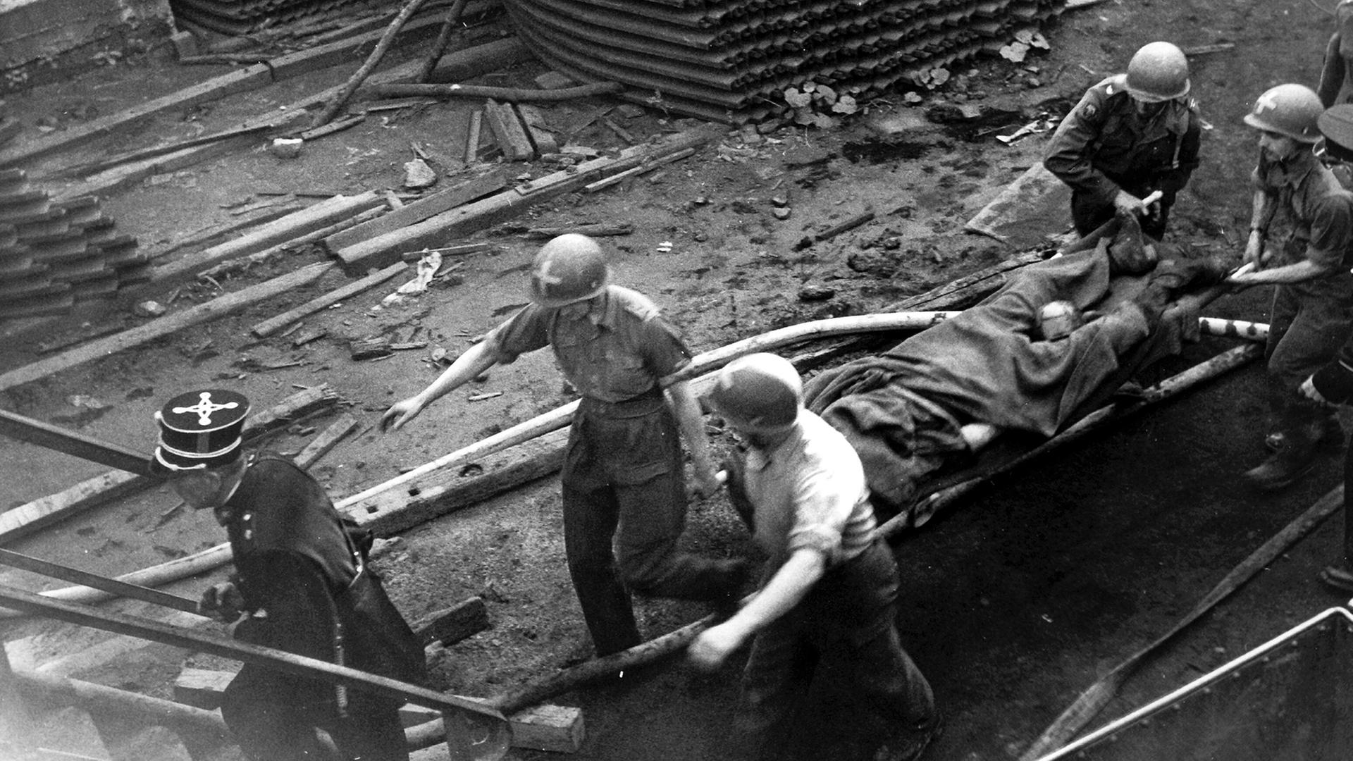 Sanit�ter der belgischen Armee transportieren einen geborgenen Toten aus dem Bergwerk in Marcinelle ab. (Archivbild: 9. 8.1956) | picture-alliance / dpa