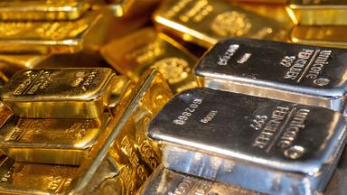 Gold- und Silberbarren in unterschiedlicher Größe liegen beim Edelmetallhändler Pro Aurum in einem Tresor auf einem Tisch.