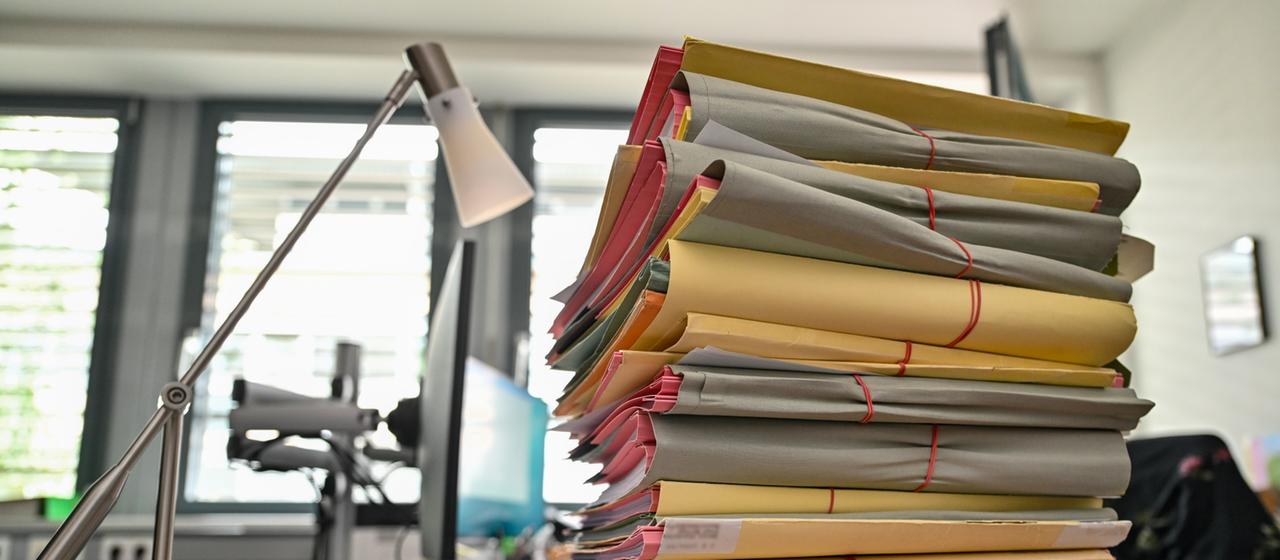 Ein Stapel mit Akten liegt auf dem Schreibtisch am Gericht. 