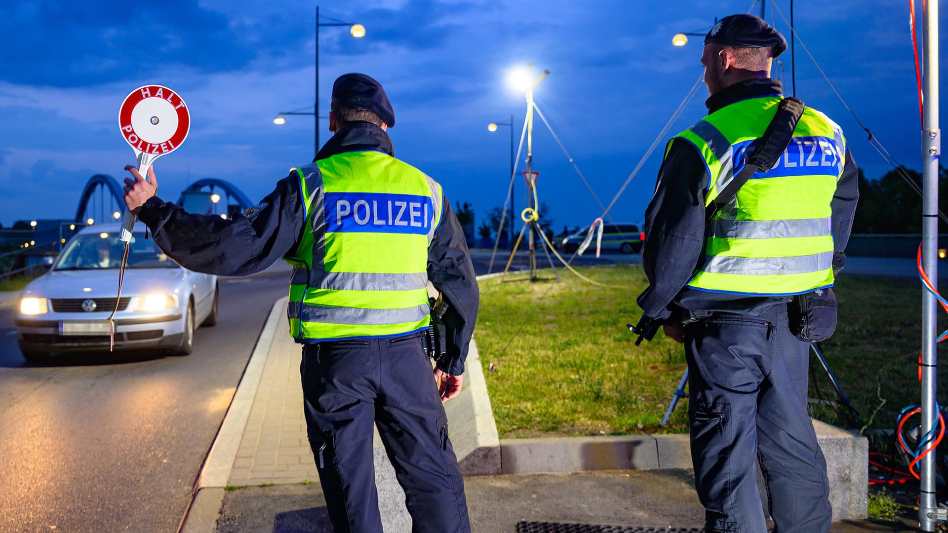 Beamte der Bundespolizei halten ein Auto mit hilfe eines Anhaltestabs an. | dpa