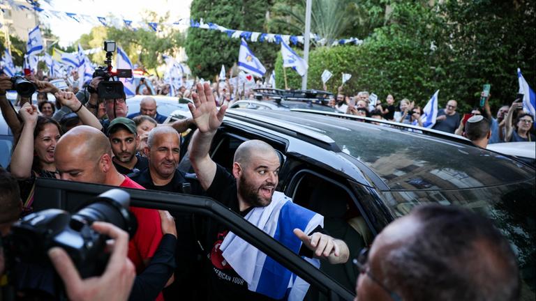Die frühere Geisel Eitan Horn winkt beim Aussteigen einem Auto der Menschenmenge zu.