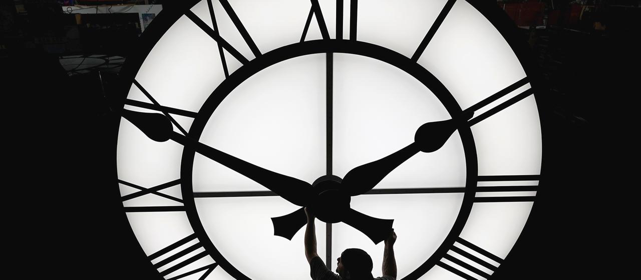 Ein Techniker bewegt die Uhrzeiger einer 500 kg schweren Uhr mit einem Durchmesser von mehr als 3,5 Metern, USA | dpa Ein Techniker bewegt die Uhrzeiger einer 500 kg schweren Uhr mit einem Durchmesser von mehr als 3,5 Metern, USA