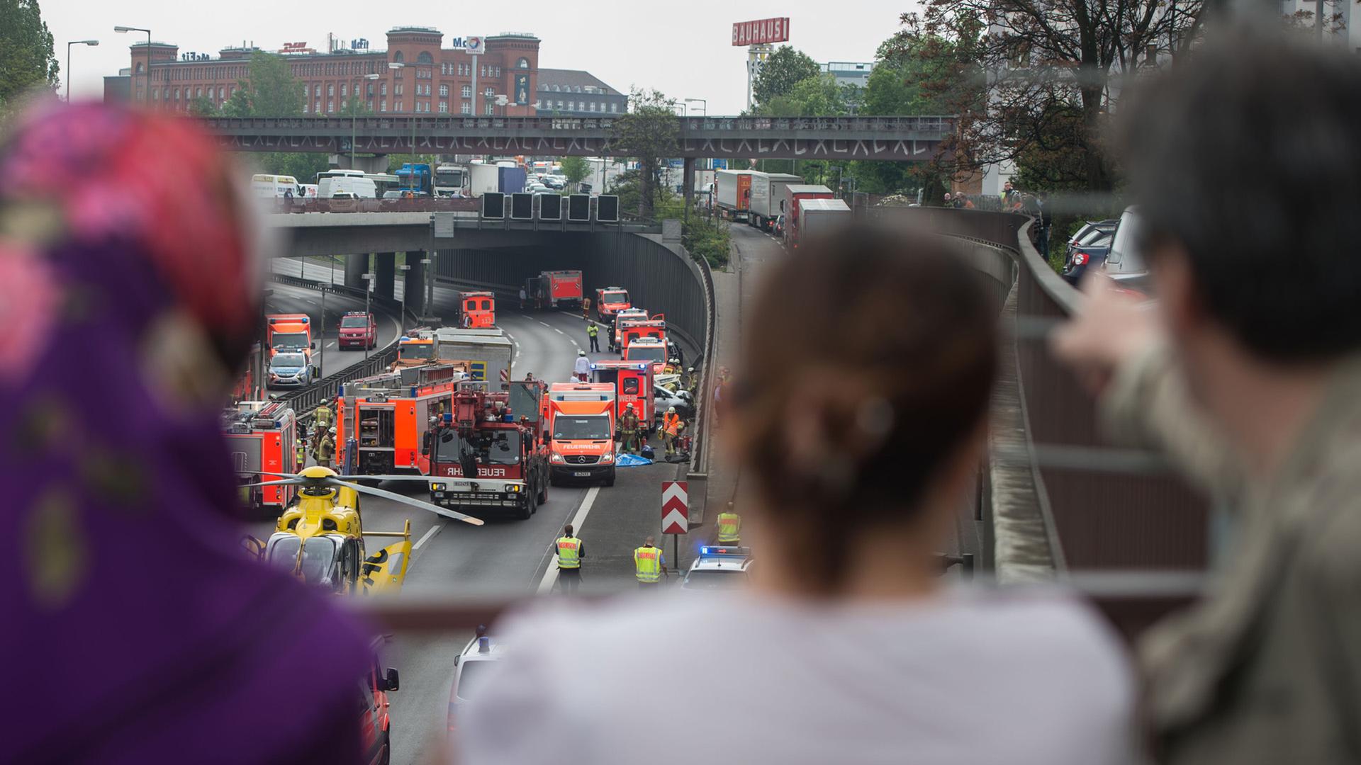Schaulustige stehen auf einer Brücke und beobachten einen Unfall. | picture alliance/dpa