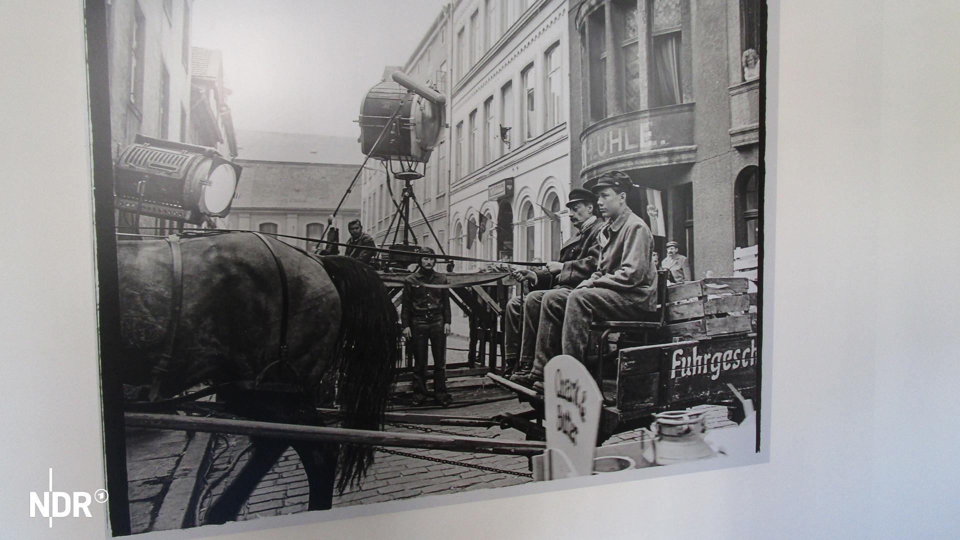 Foto von Ernst Höhne von den Dreharbeiten zu "Aus meiner Kindheit" | Axel Seitz Ein Foto zeigt einen Mann und einen Jungen, die auf einem Kutschbock sitzen, dahinter Männer mit einer großen Filmkamera