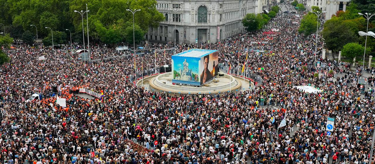 Eine große Menschenmenge mit Bannern in Madrid