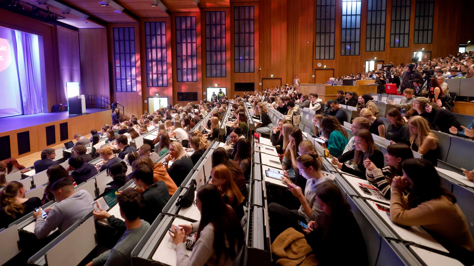 Studenten lauschen im großen Hörsaal am Tag der Erstsemesterbegrüßung. | IMAGO/Panama Pictures/IMAGO/Christoph Hardt