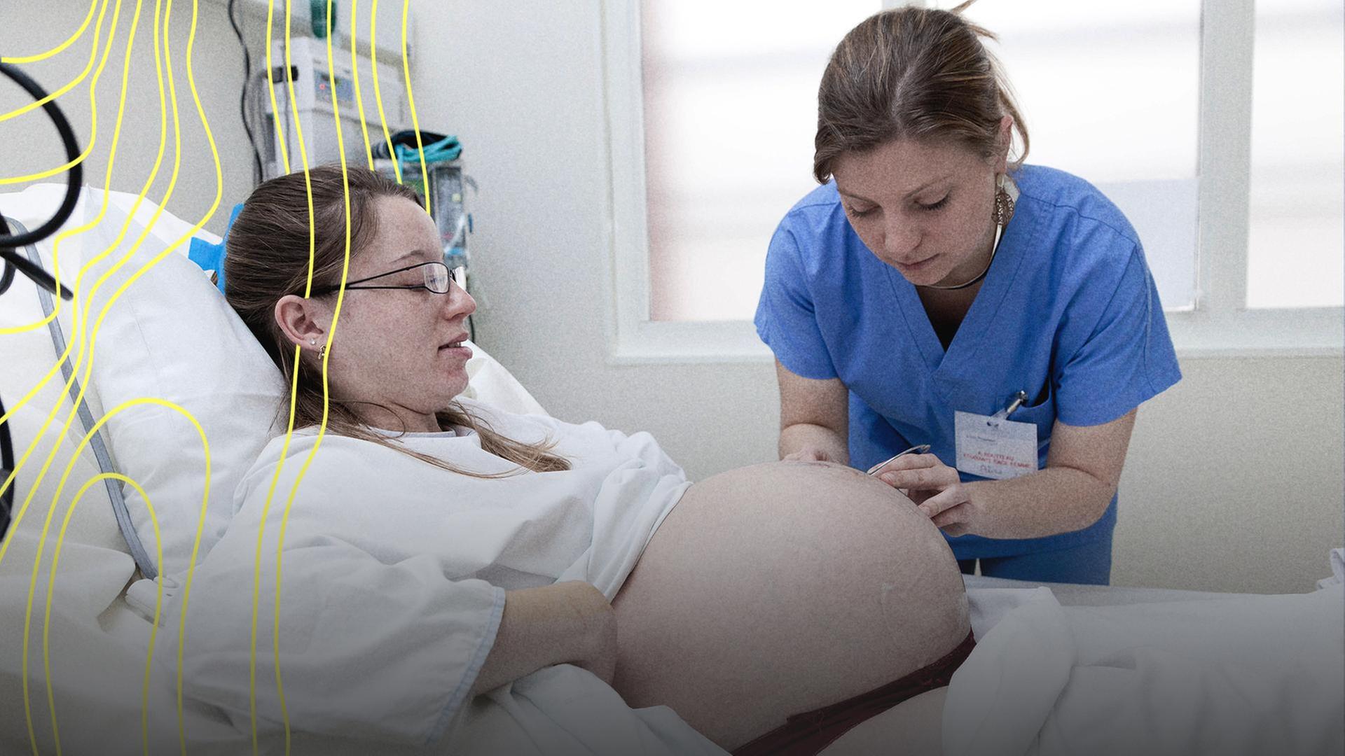 Eine Hebamme kÃ¼mmert sich um eine Schwangere. | IMAGO / BSIP