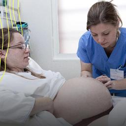 Eine Hebamme kümmert sich um eine Schwangere.