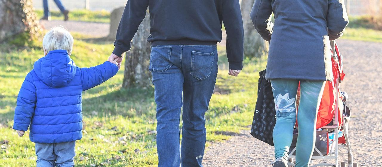 Eltern mit ihren Kindern gehen spazieren.