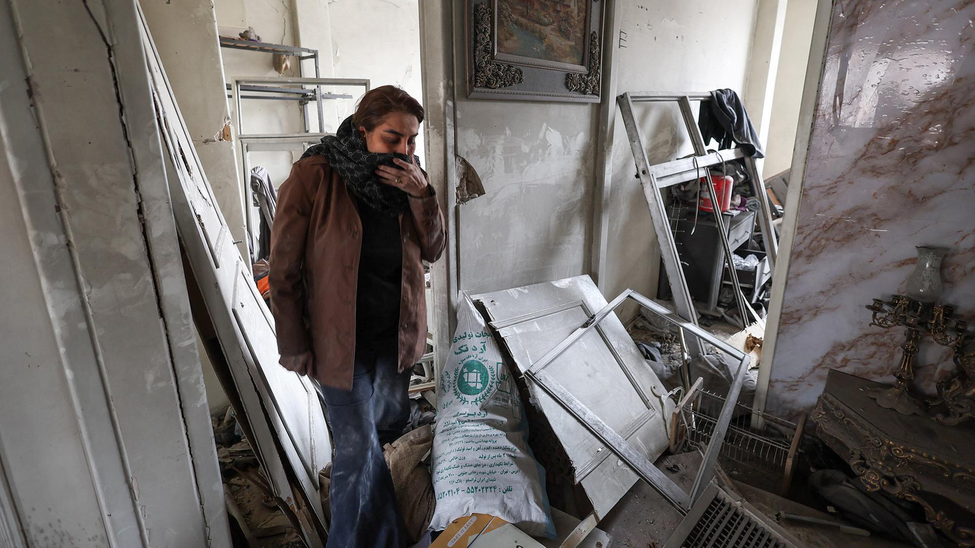 Eine Frau begutachtet die Schäden in ihrer Wohnung. | REUTERS