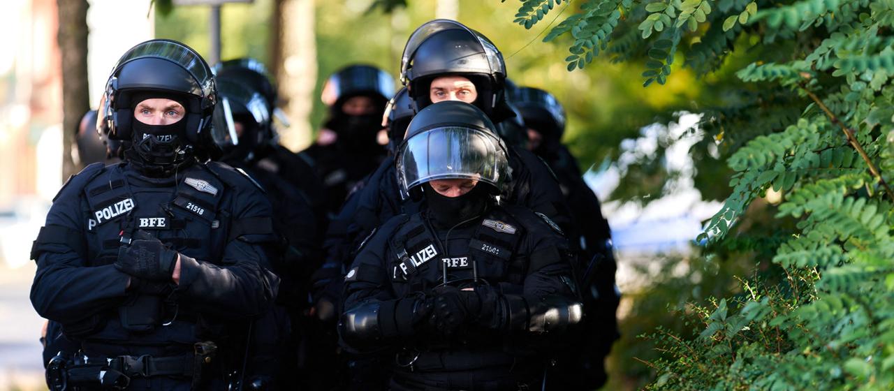 Polizeibeamte stehen am Rande einer Demonstration.