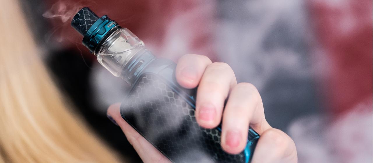 Eine junge Frau raucht eine E-Zigarette