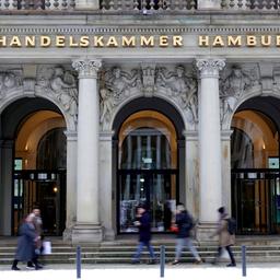 Menschen laufen über den Gehweg vor dem Gebäude der Handelskammer in Hamburg.