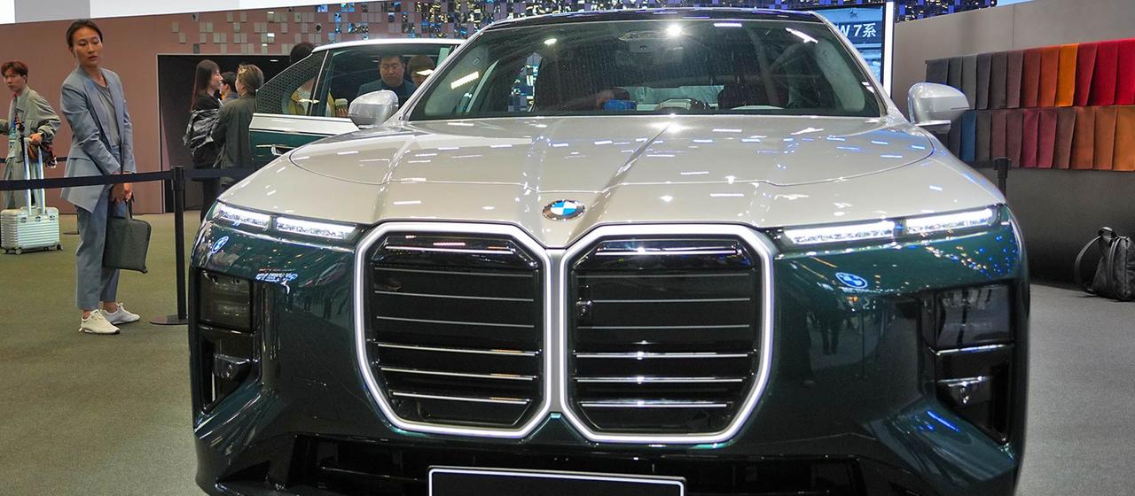 Messebesucherin neben einem BMW i7 auf der Auto China 2026.