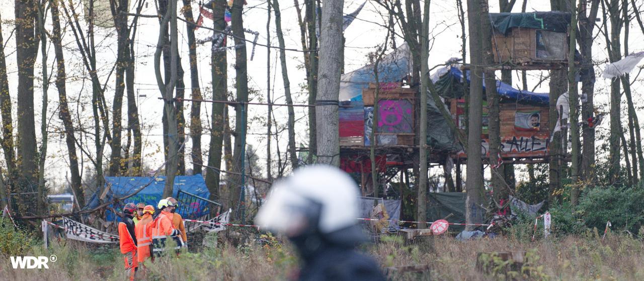 Einsatzkräfte vor Baumhäusern