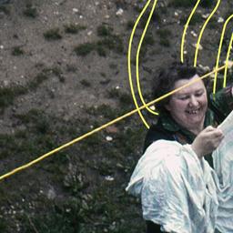 Eine Frau hängt in den 60ern Wäsche an eine Wäscheleine.