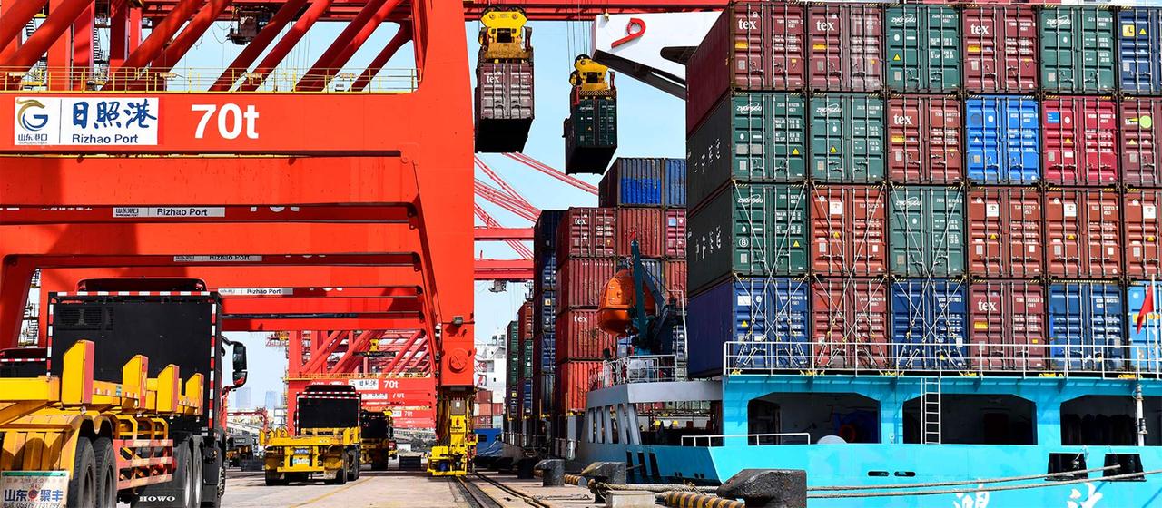 LKWs bei der Beladung mit Containern, Hafenterminal, Rizhao, Shandong, China.