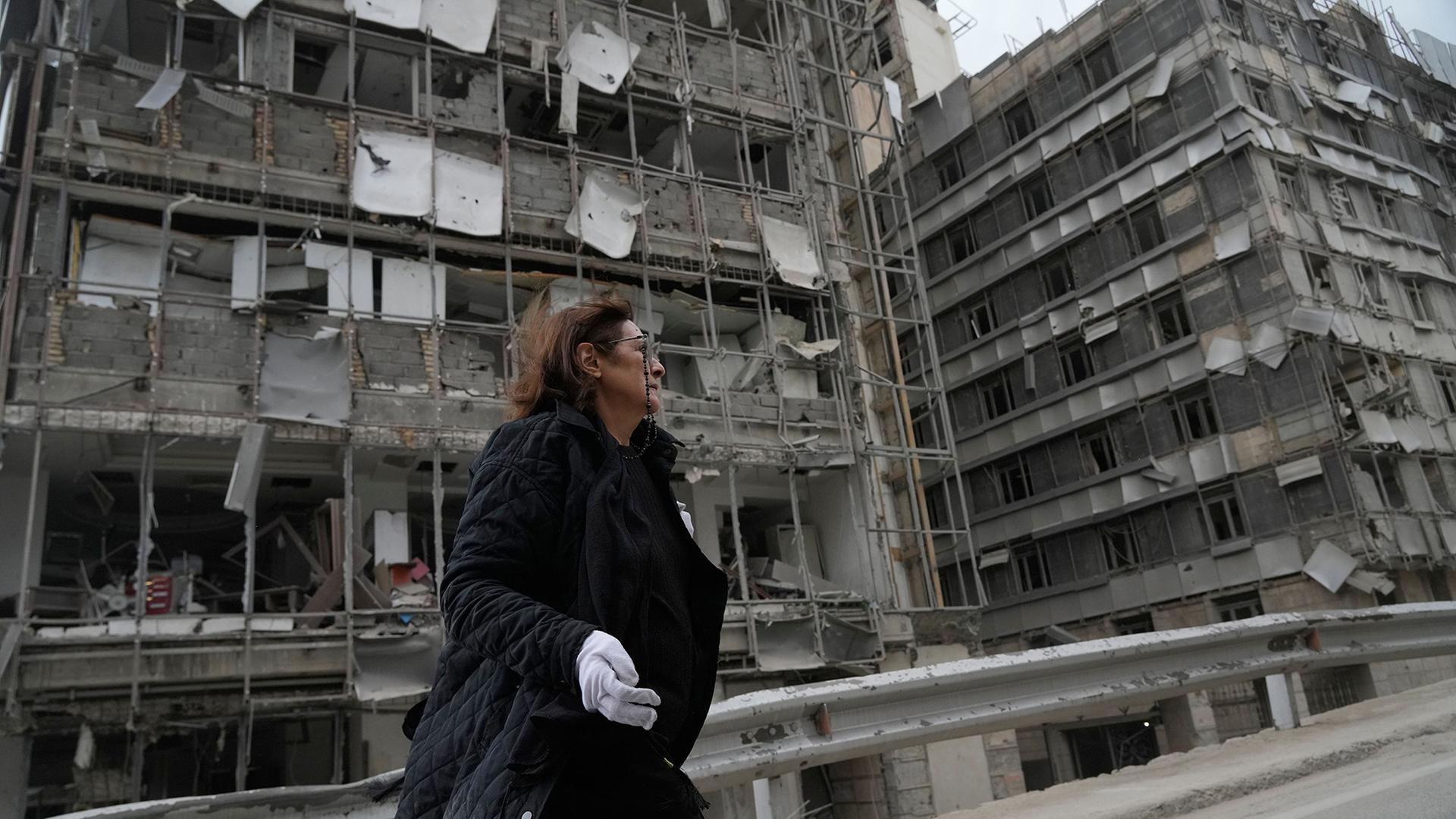 Eine Frau geht an dem beschädigten Gandhi-Krankenhaus in Teheran vorbei, das bei einem Luftangriff getroffen wurde. | Vahid Salemi/AP/dpa