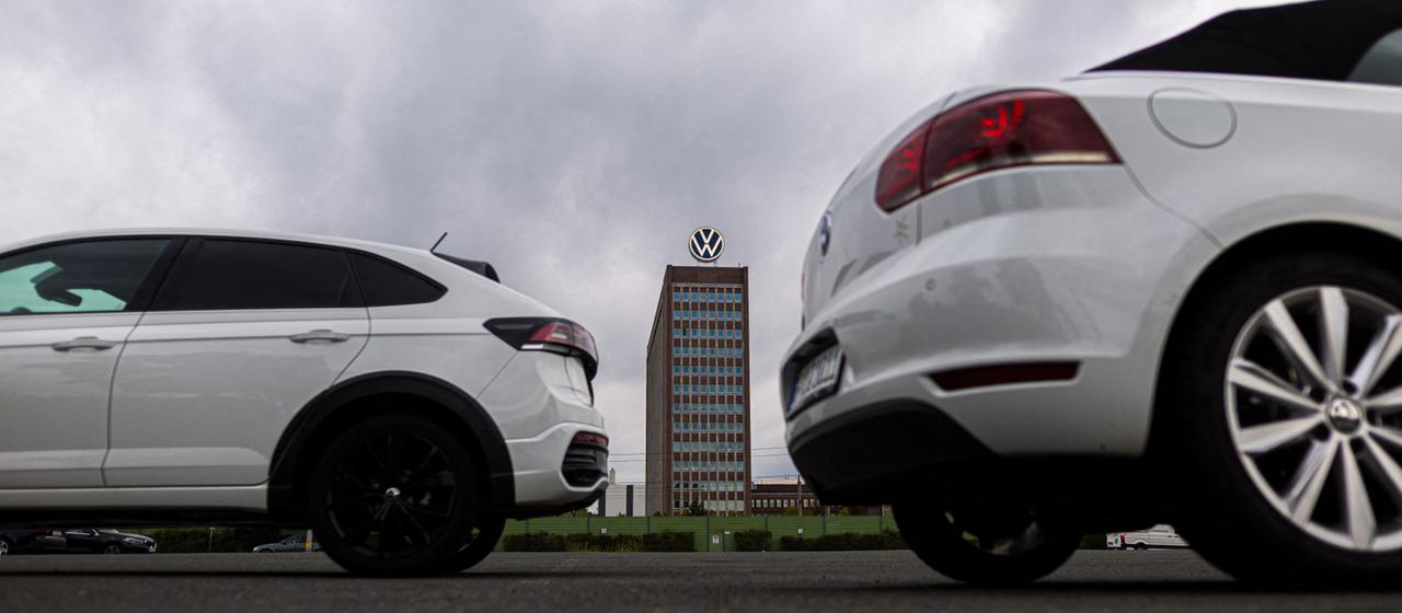 Autos von VW parken vor dem VW-Markenhochhaus.
