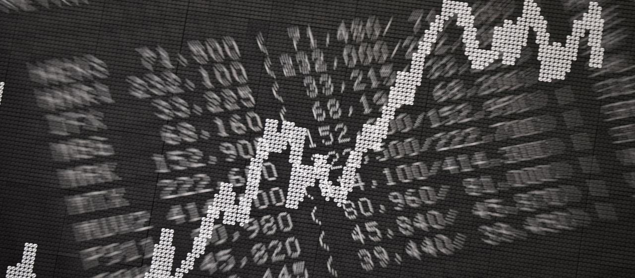 Eine Anzeigetafel mit Kursen von Unternehmen sowie der DAX-Kurve