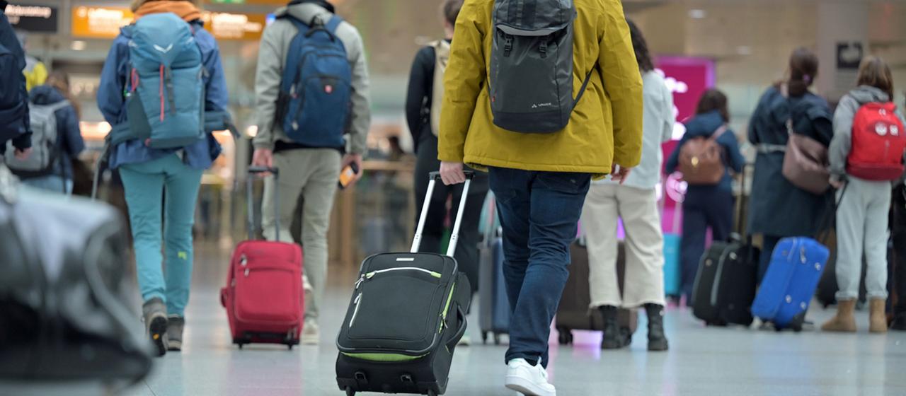 Reisegäste gehen zum Check-in am Flughafen.