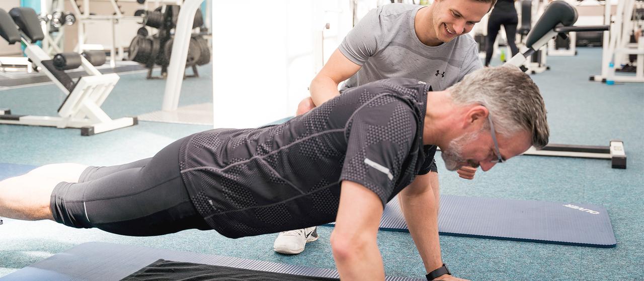 Ein Mann macht unter Anleitung Sportübungen in einem Fitnessstudio. | Mathis Fit Life GmbH/obs Ein Mann macht unter Anleitung Sportübungen in einem Fitnessstudio.