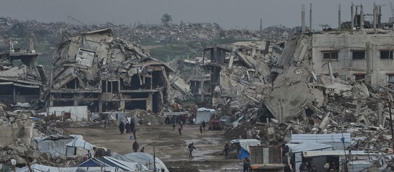Palästinenser gehen zwischen zerstörten Gebäuden im Stadtteil Zeitoun in Gaza-Stadt.