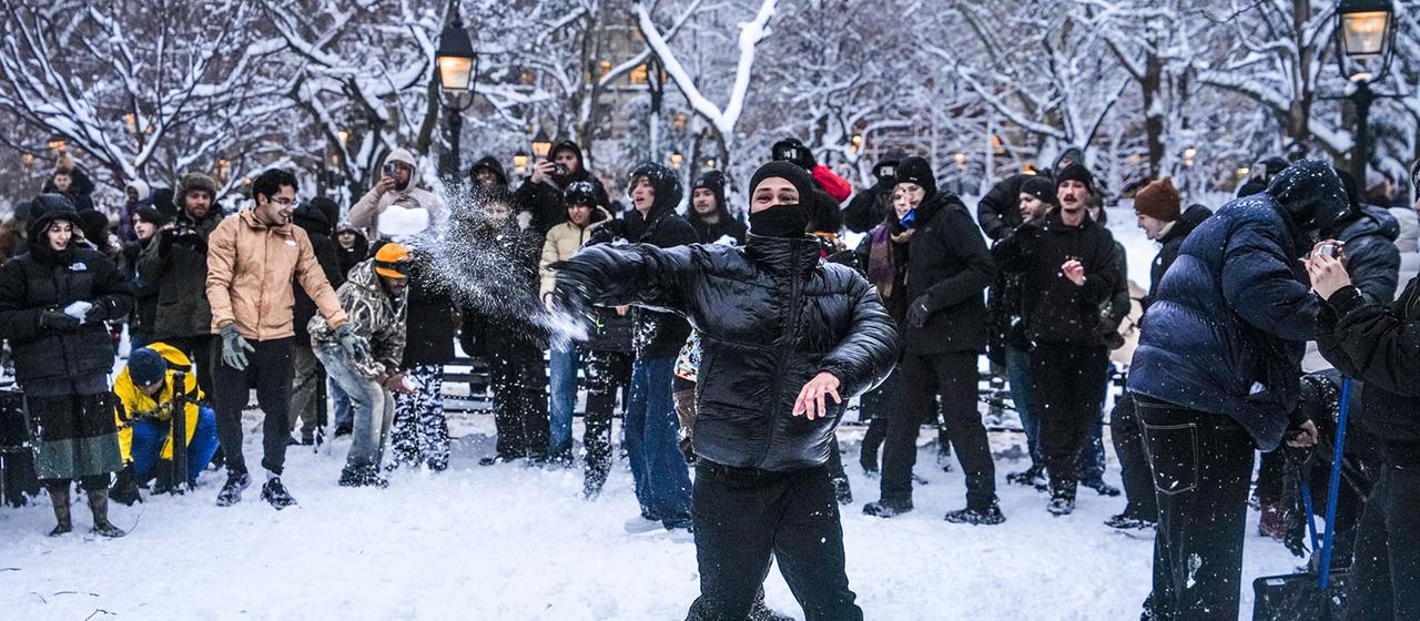 Im Washington Square Park in New York City findet eine Schneeballschlacht statt.