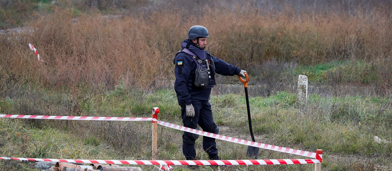 Ein ukrainischer Minenexperte steht neben Blindgängern und Landminen an der Hauptstraße nach Cherson.