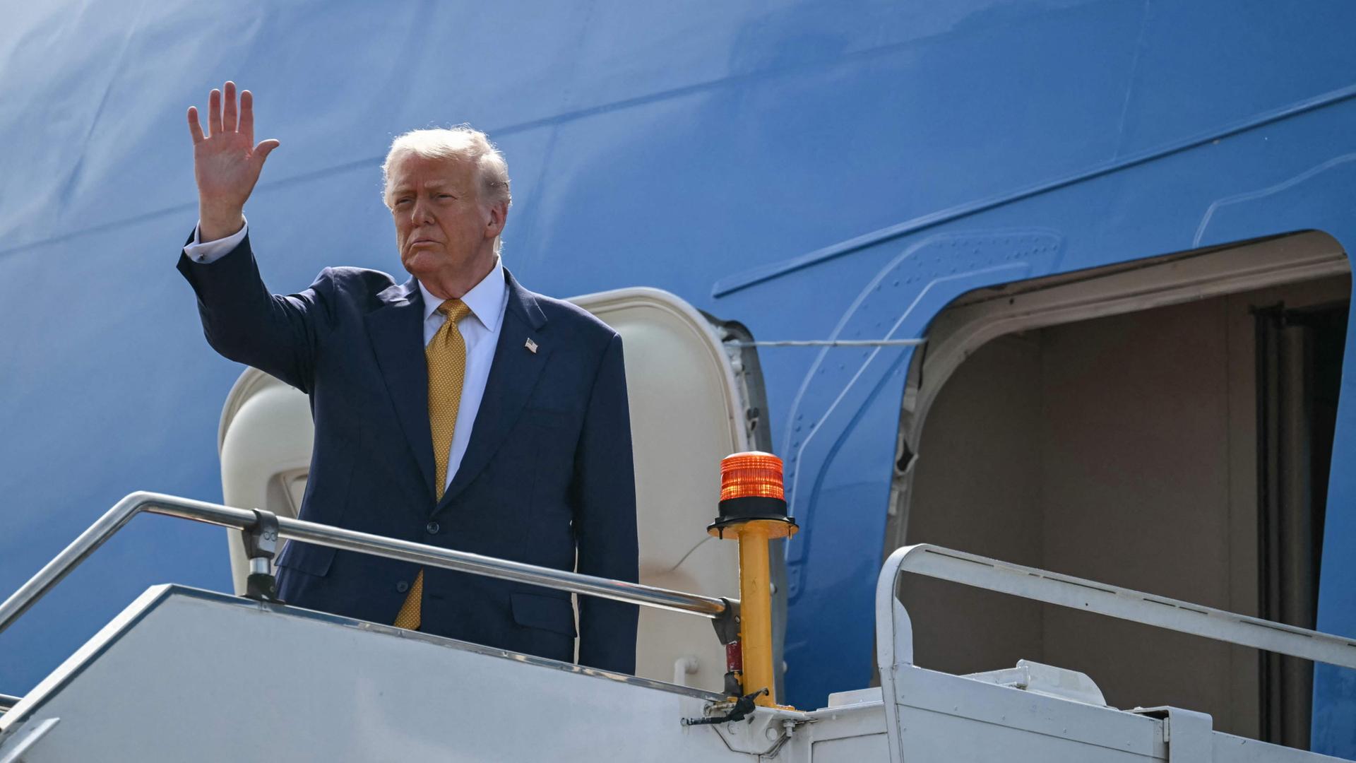 Donald Trump winkt bevor er in das US-Regierungsflugzeug Air Force One steigt. | AFP