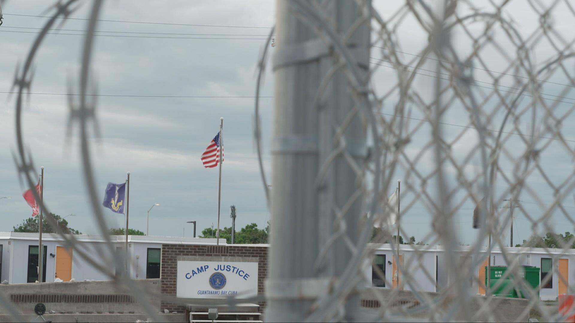 Der Blick durch einen Zaun auf Gebäude des 