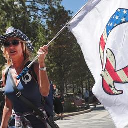 Eine Frau mit einer QAnon-Flagge besucht das Mount Rushmore National Monument in Keystone, South Dakota, USA