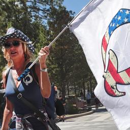 Eine Frau mit einer QAnon-Flagge besucht das Mount Rushmore National Monument in Keystone, South Dakota, USA