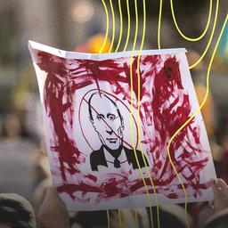 Auf einer Demonstration wird ein Plakat hochgehalten auf dem ein Bild von Putin durchgestrichen ist.