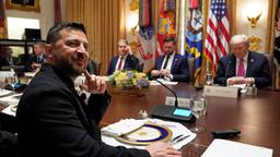 Wolodymyr Selenskyj und JD Vance und Donald Trump im Hintergrund.