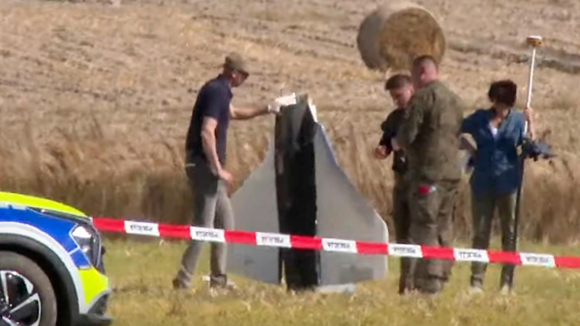 Videostandbild: Einsatzkrfte von Polizei und Militrpolizei sichern in Wohyn, Polen, Teile einer beschdigten Drohne. | dpa