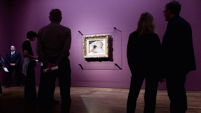 Auf dem Bild ist zu sehen, wie verschiedene Museumsbesucher das Gemälde "Der Ursprung der Welt" anschauen 