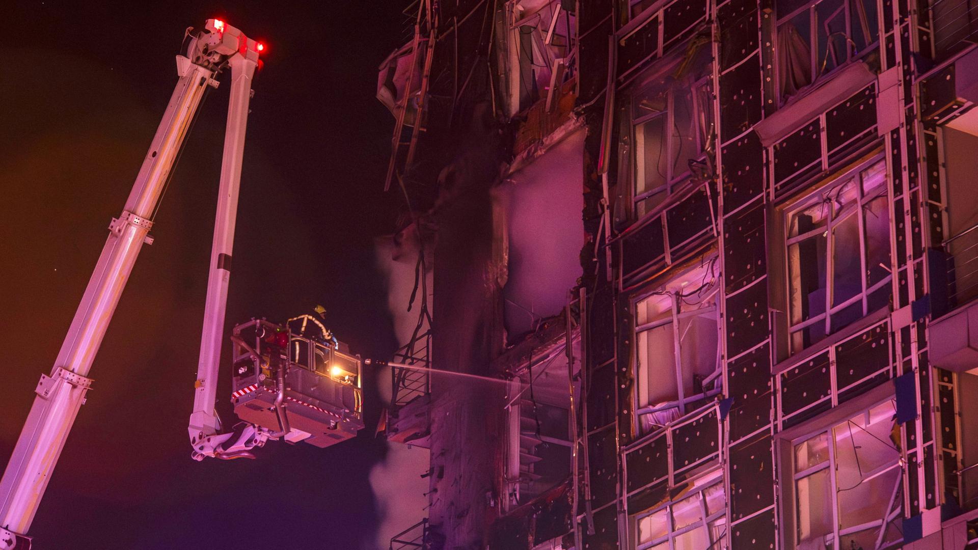 Rettungskräfte an einem zerstörten Gebäude in Kiew | dpa