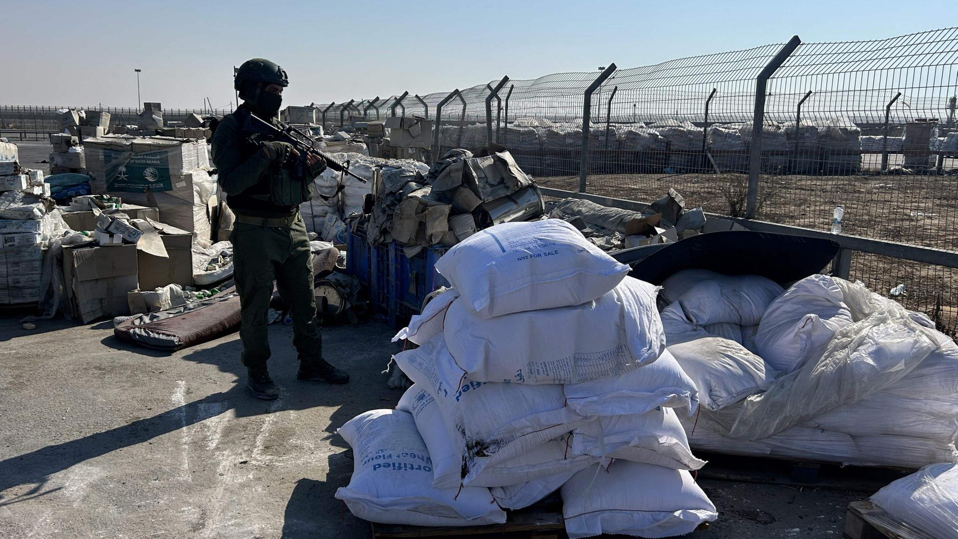 Ein israelischer Soldat steht neben humanitären Hilfsgütern am Grenzübergang Kerem Shalom zwischen dem Süden Israels und dem Gazastreifen. | AFP